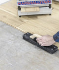Person using Striker XXL Tapping Block No Mallet Needed for Mallet-Free Flooring Install on engineered wood planks