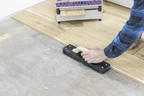 Person using Striker XXL Tapping Block No Mallet Needed for Mallet-Free Flooring Install on engineered wood planks
