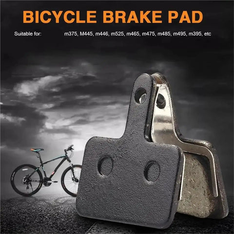 Fifteen Pair Top Shelf Bicycle Brake Pads Resin Compound Rotor Replacement For Hydraulic Disc Systems With Killer Grip Stopping Power And Ride Easy Durability, black and metallic brake pad close-up on road.