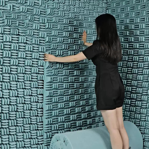 Person installing Kickass Heavy Duty Sound Proof Padding on wall, showcasing High Density Acoustic Foam Rolls in blue.