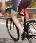 Cyclist riding on road with Lumina 1000 Boost Front Bike Light with Sabre 110 Rear Light USB Rechargeable LED Set