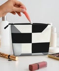 Level Up Your Packing Game With This Legit Black And White Piano Grid Print Large Toiletry Bag Crafted From Water Repellent Polyester Fabric For Hassle Free Travel Essentials And Cosmetics. Hand reaching for cosmetics in stylish black and white grid print toiletry bag.