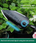Heavy Duty Stainless Steel Garden Trowel With Non Slip Rubber Handle For Digging Weeding Transplanting And Soil Scooping Serrated Three Inch Edge For Cutting Roots And Weeds Built Tough Workhorse For Rocky Dirt in a garden scene.