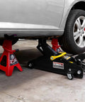 Car lifted by 2 Ton Hydraulic Floor Jack With Two Jack Stands Red And Black 4000 Lbs Capacity Trolley Service Jack Combo