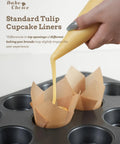 Pouring batter into unbleached 200 Pack Natural Tulip Cupcake Liners for Standard Muffin Pans on a baking tray.
