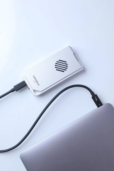 USB4 NVMe Enclosure With Active Cooling Fan And Solid Aluminum M.2 SSD Case connected to a Mac laptop.