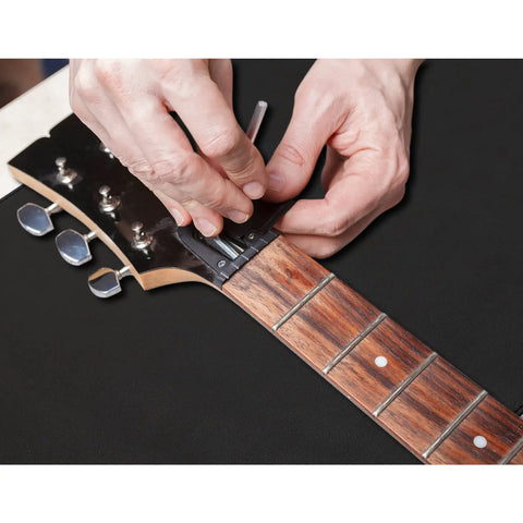 Hands adjusting a guitar with All In One Guitar Repair Kit With Neck Rest Cradle And Pro Grade Gig Ready Work Mat For Studio And Shop
