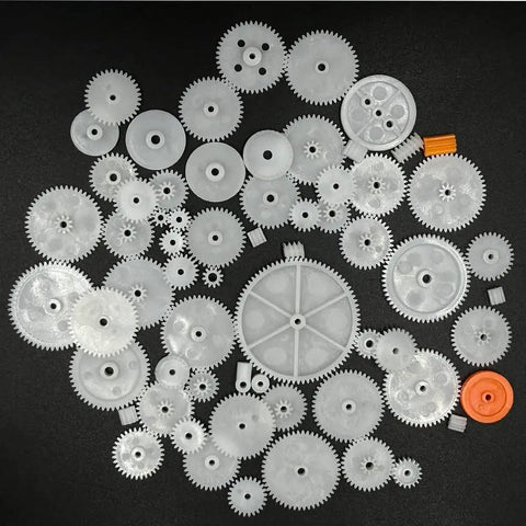 64Pcs 0.5 Module Plastic Gears Kit For DC Motors And DIY Robots laid out, includes various spindle, crown, single, and double gears