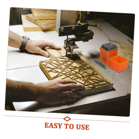 37 Piece Metal Letter And Number Stamp Set With Heart Symbols Punch Kit next to hands carving wood on a workbench.