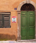 Leave Your Packages Here Heavy Duty Aluminum Front Porch Drop Off Sign 12X8 Inches on a wall near a green door for outdoor use.
