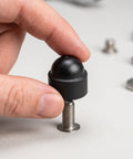 Hand holding M8 Black Plastic Hexagonal Dome Nut Cap on a bolt, part of 50 Pack Impact Resistant Protective Covers for Hex Nuts.