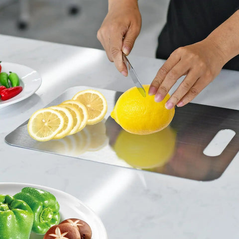 Cutting lemon on stainless steel board from Three Piece Stainless Steel Cutting Board Set With Double Sided Thick Boards
