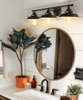 Industrial Rustic 3 Light Vanity Wall Sconce in Dark Bronze with Vintage Gold Trim above bathroom mirror