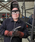 Built Dog Gone Tough 6-Pack Welding Goggles Featuring Auto Darkening Lenses For Serious Shop Work snug fit on a worker in gloves holding welding tools.