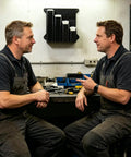 Two men in a workshop with Heavy Duty Wall Mount Zip Tie Organizer Rack With Aluminum Construction on the wall.