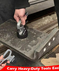 Front view of MUTUACTOR grey magnetic pickup tool with release handle lifting a thick iron plate.
