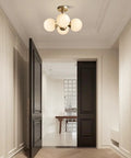 Entryway with Antique Brass 4 Light Ceiling Light With Frosted Glass Globes, Mid Century Modern Chandelier illuminating space.