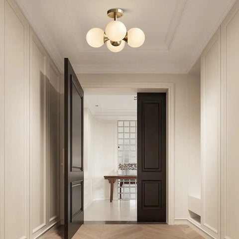 Entryway with Antique Brass 4 Light Ceiling Light With Frosted Glass Globes, Mid Century Modern Chandelier illuminating space.