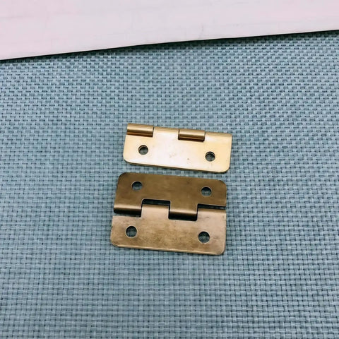 42 Piece Mini Hinge Set in Antique Bronze Finish With Rounded Corners on blue surface