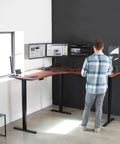 VIVO Corner Standing Desk In Dark Walnut L Shaped Electric Height Adjustable Workstation with dual monitors in use.