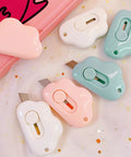 9 Pack Retractable Box Cutter Set with Cloud Charm featuring mini cutters in pink, white, and blue on star-patterned fabric.