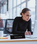 24 Pack Acrylic Name Plates For Desk 2x8 Inches Clear Slant Back Sign Holders visible on office desk in use