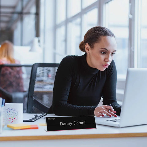 24 Pack Acrylic Name Plates For Desk 2x8 Inches Clear Slant Back Sign Holders visible on office desk in use