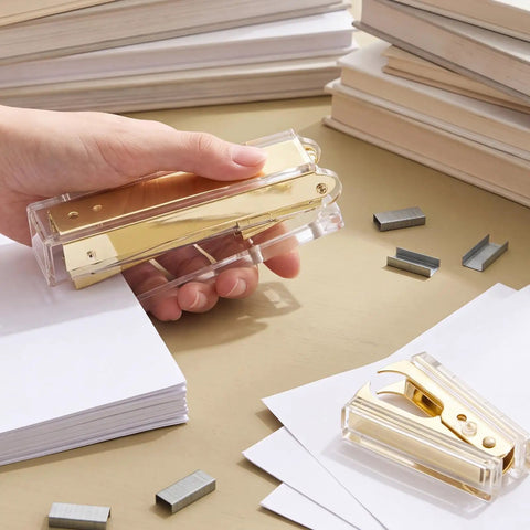 Hand holding the Gold Desk Stapler Set With Acrylic Finish, 20 Sheet Capacity, Includes Staple Remover And 1000 26 By 6 Staples