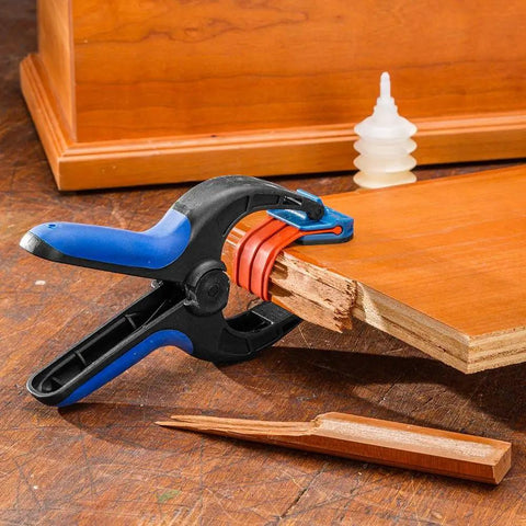 Medium Bandy Clamps Set For Woodworking With Easy Squeeze One Handed Operation holding wood edge with glue bottle on table