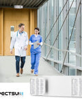 12 Pack Commercial LED Emergency Light With Dual Heads Hardwired Battery Backup For Power Outages shown in a hallway with healthcare workers.