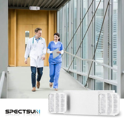 12 Pack Commercial LED Emergency Light With Dual Heads Hardwired Battery Backup For Power Outages shown in a hallway with healthcare workers.