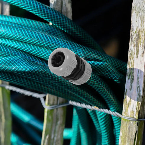 Get Your Garden Hose Back In Action With This Sturdy 4 Piece Repair Kit Featuring Quick Connect Adapters That Make Installation A Breeze For Watering Plants And Keeping Everything Leak Free. Gray plastic hose repair connector on coiled green garden hose
