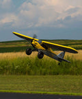 RC Airplane Carbon Cub S 2 1.3m ready to fly with SAFE technology in action outdoors, yellow and gray design, no battery and charger