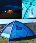 Solar Powered Lamp With Remote Control hanging in tent, illuminating night fishing setup, showcasing efficient solar panel charging