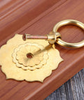 Antique Brass Ring Pulls For Cabinets And Doors Hexagon Flower Design on wooden surface, single pull with screw visible for easy installation.