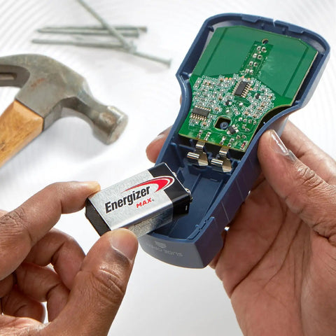 Person inserting 9V alkaline battery into a meter, showcasing reliable 9 volt battery pack for home use
