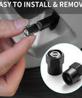 Person installing black aluminum tire valve stem cap on car wheel, showcasing 4 Pack Aluminum Tire Valve Stem Caps For Cars Black Anodized Metal Wheel Air Caps Auto Valve Covers Protectors Durable Alloy Caps That Prevent Wear And Keep Your Tires Looking Sharp. Close-up of cap design.