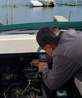 Person using Camera Assisted Retrieval Tool With 32 Inch Bendable Gooseneck Four Prong Claw Live 480P Video On Two Point Eight Inch LCD Four LED Lights Magnetic Tip Pulls Ferrous Objects From Tight Spaces For Contractors Mechanics And DIY Pros Orange on boat engine.