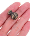 Close-up of Vintage Pumpkin Drawer Pulls 12 Piece Set Old School Round Cabinet Knobs For Jewelry Boxes Cupboards And Furniture Hardware In Small Lantern Green Bronze Finish With A Comfy Grip on a hand.