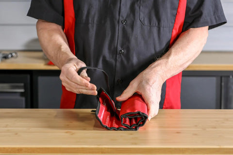 Person holding roll pouch of Heavy Duty Built To Last Pro Grade 16 Piece Punch And Chisel Set for automotive and DIY projects