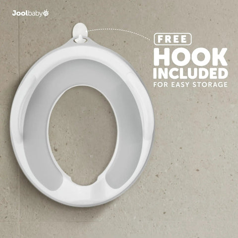 Toddler Potty Training Seat With Sure Grip Handles And Non Slip Base For An Easy Peasy Transition To The Big Toilet Includes Splash Guard Plus Handy Wall Hook Gray positioned on a surface with a free storage hook.