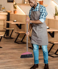 Man using Long Handle Broom With Dense Stiff Bristles Heavy Duty Floor Sweeper in a restaurant with wooden floors.
