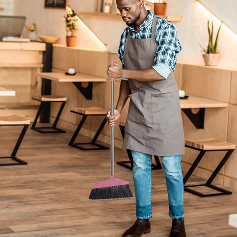Man using Long Handle Broom With Dense Stiff Bristles Heavy Duty Floor Sweeper in a restaurant with wooden floors.