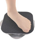 Close-up of foot on CRS Cross Figure Skating Spinner 8-inch training aid with black foam surface and metal base