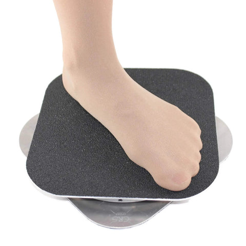 Close-up of foot on CRS Cross Figure Skating Spinner 8-inch training aid with black foam surface and metal base