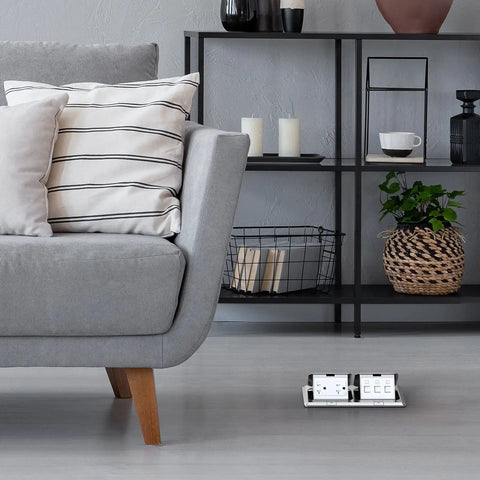 Dual Pop Up Floor Box Kit With 20A Tamper Resistant Duplex Outlet And 3 Port RJ45 Datacom Receptacle in brushed nickel under sofa