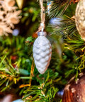 Tough As Nails Zinc Plated Eye Lag Screws In A Solid 100 Pack Plus A Handy Hook Driver For Snagging Drop Ceiling Hangers And Locking Wire Tight To Wooden Joists No Sweat Indoors Or Out, decorative pinecone ornament hanging on a Christmas tree.
