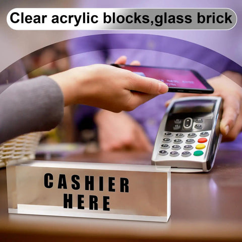 Cashier here sign displayed on a clear acrylic block next to a payment terminal
