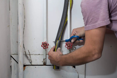 Person installing Insulating Foam Pipe Covers 0.75 Inch By 3 Feet Pack Of 4 Sticks Self Sealing Pre Slit on pipe