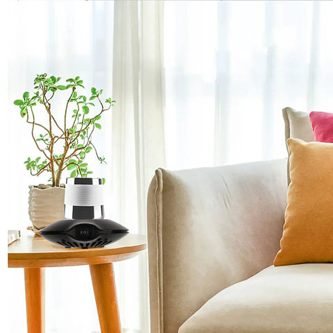 Electric Coffee Mug Warmer With Heating Cooling Cup Mat USB Drink Heater on table next to a plant in a cozy living room.
